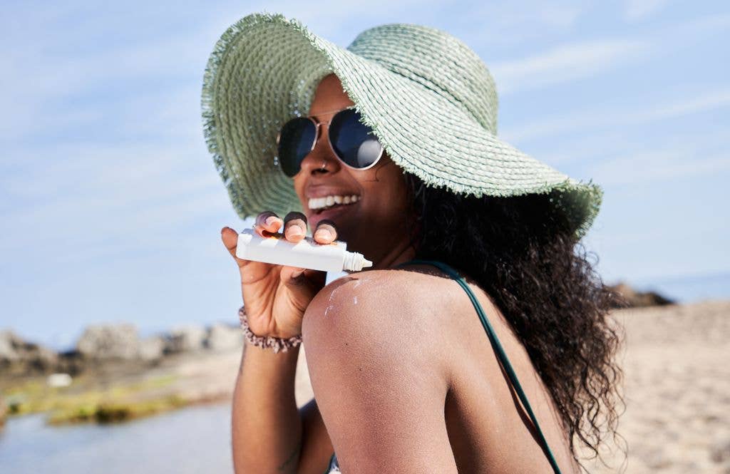 woman applying sunscreen at beach