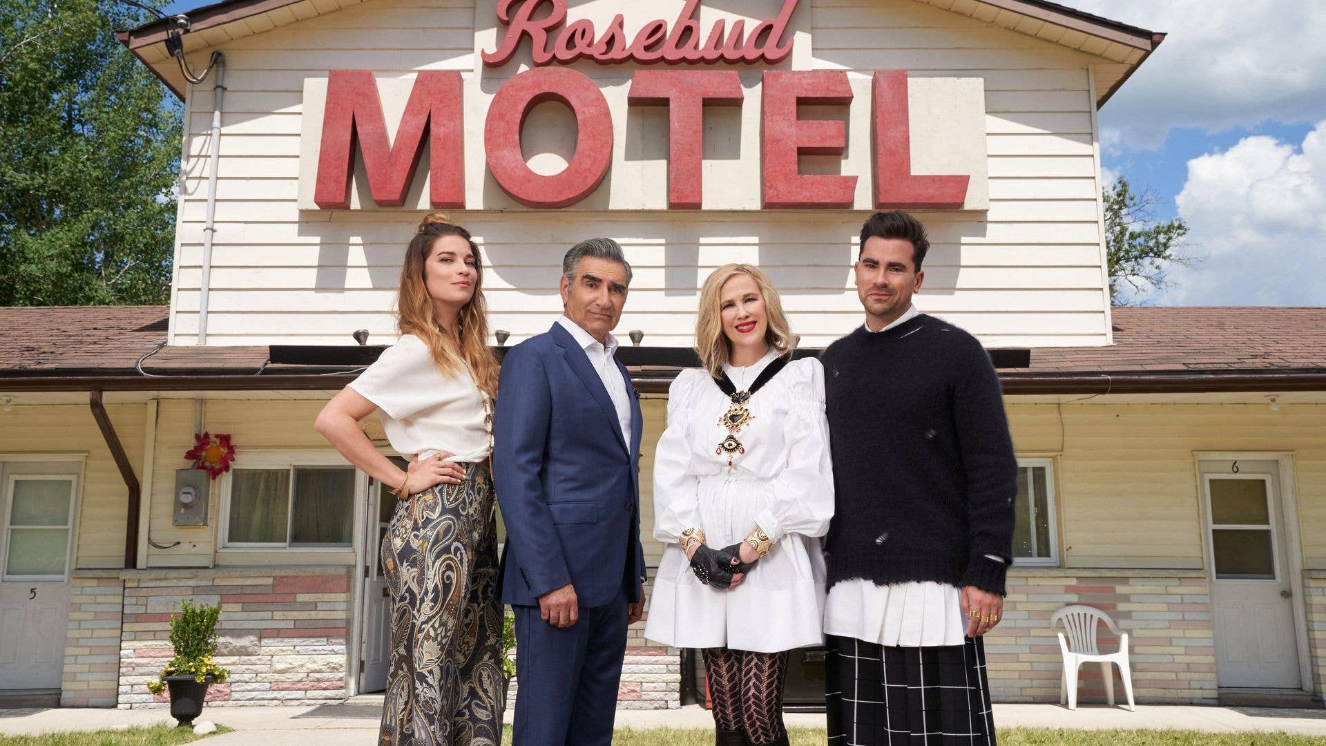 Annie Murphy, Eugene Levy, Catherine O'Hara, and Daniel Levy stand in front of the Rosebud Motel.