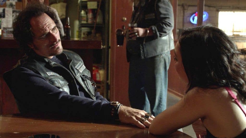 Still from Sons of Anarchy; Tig and Dawn sit at a table
