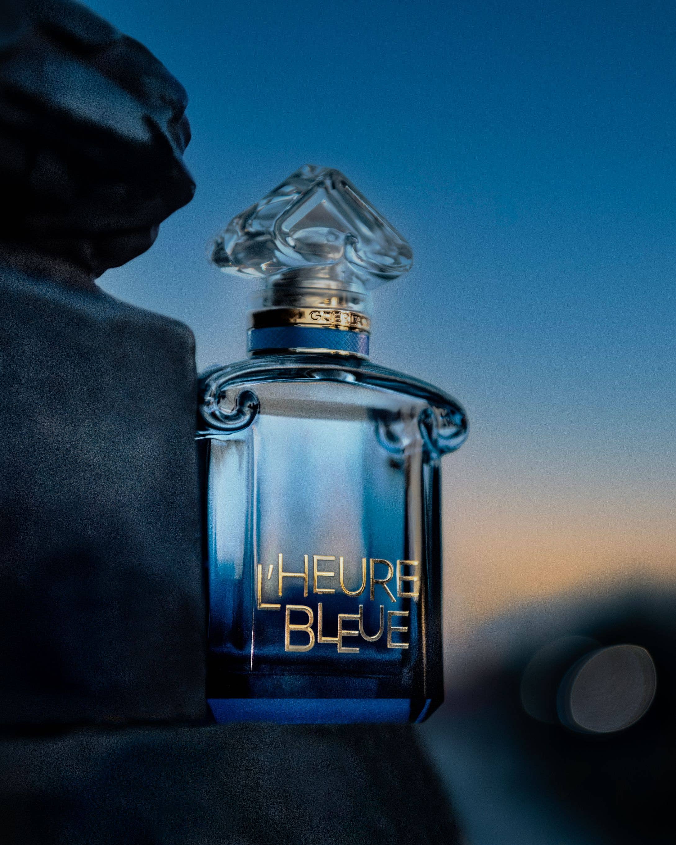L'Heure Bleue perfume bottle in front of a night sky