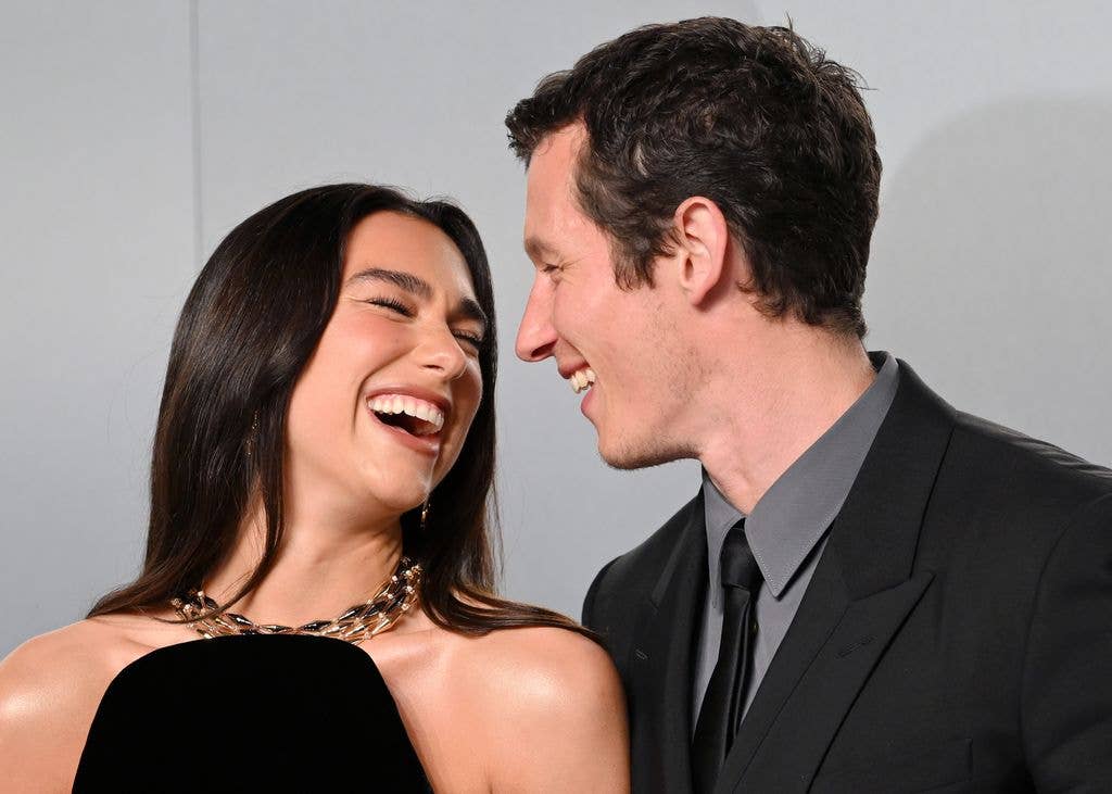 Dua Lipa and Callum Turner smile at one another in a photograph from the Vanity Fair Oscar Party in 2026.