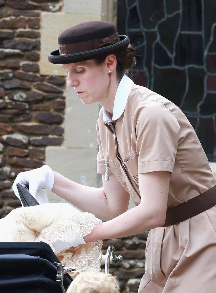 Prince George's nanny, Maria Teresa Turrion Borrallo (in her Norland Nanny Uniform) helps secure Princess Charlotte of Cambridge in her pram as she leaves the Church of St Mary Magdalene
