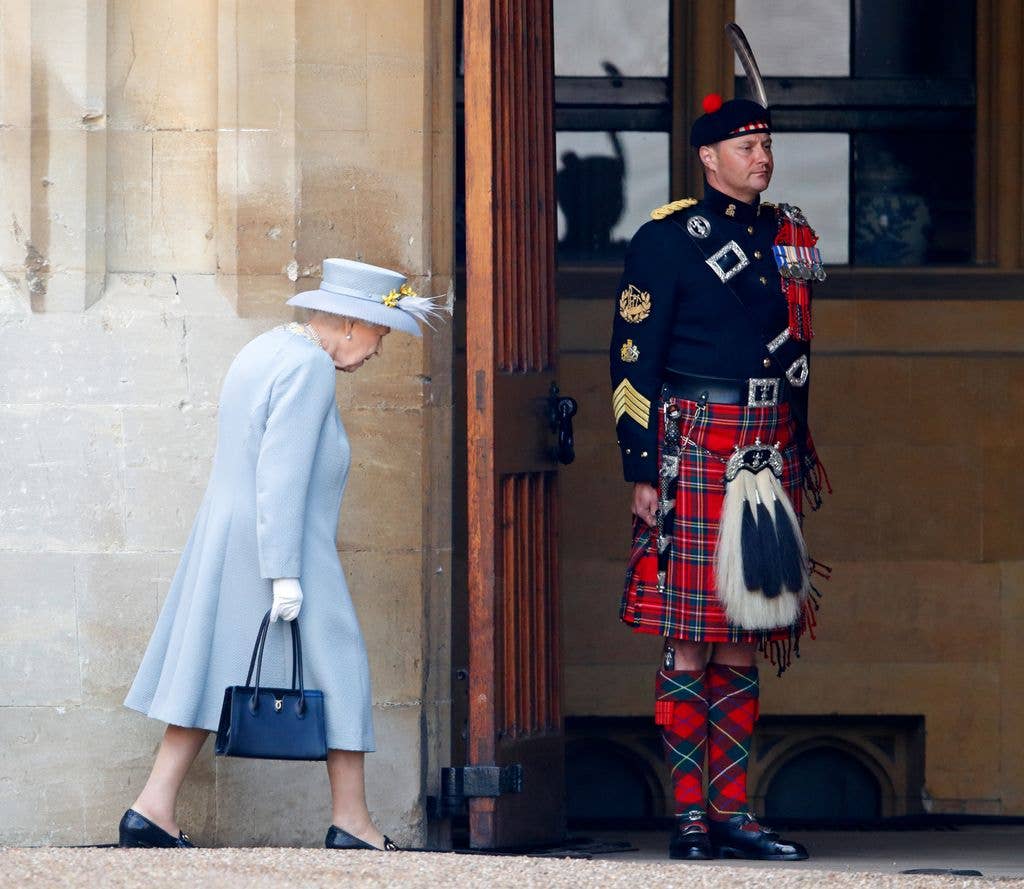 Queen Elizabeth II walks past The Queen's Piper, Pipe Major Richard Grisdale of The Royal Regiment of Scotland as she returns to Windsor Castle after attending a military parade, held by the Household Division (during which The Queen's Colour of F Company Scots Guards will be trooped) in the Quadrangle of Windsor Castle, to mark her Official Birthday on June 12, 2021 in Windsor, England. For the second consecutive year The Queen's Birthday Parade, known as Trooping the Colour, hasn't been able to go ahead in it's traditional form at Buckingham Palace and Horse Guards Parade due to the ongoing COVID-19 Pandemic.