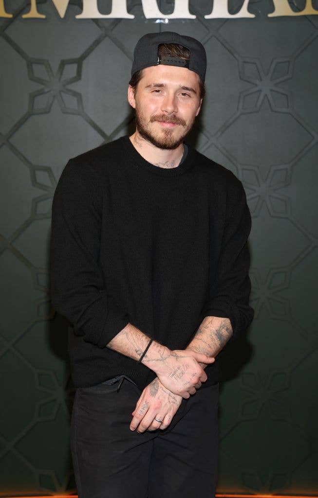 Brooklyn Beckham in a black outfit and backwards cap