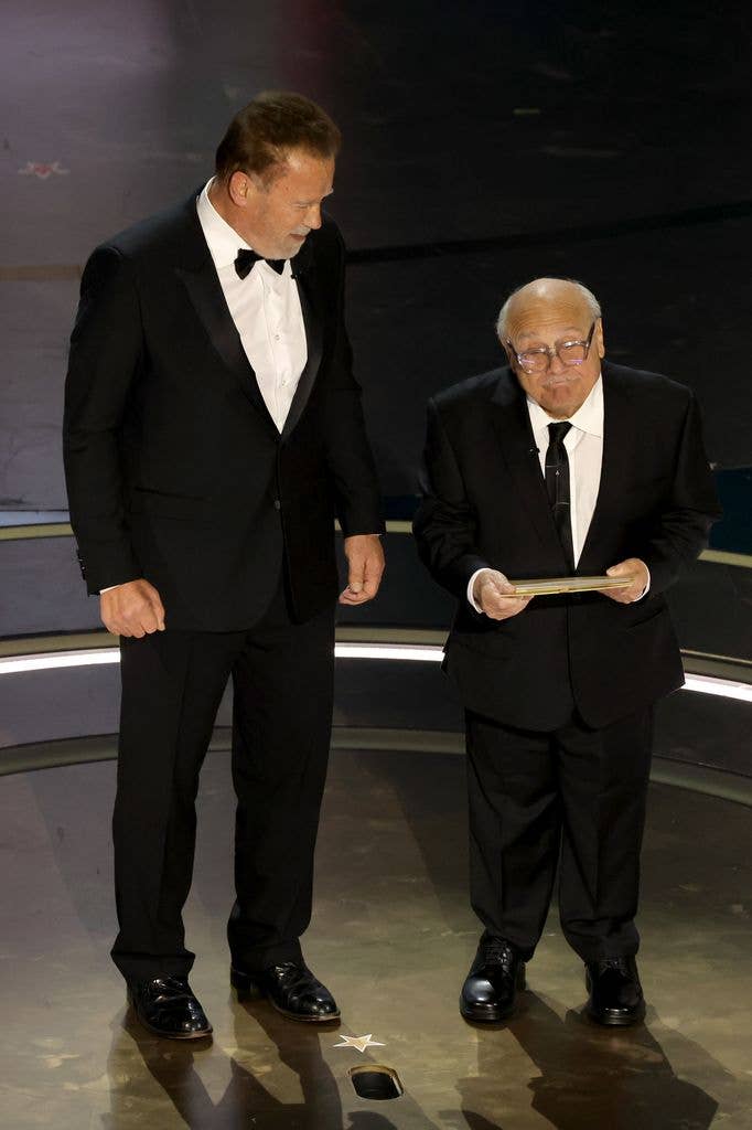 Arnold Schwarzenegger and Danny DeVito speak onstage during the 96th Annual Academy Awards