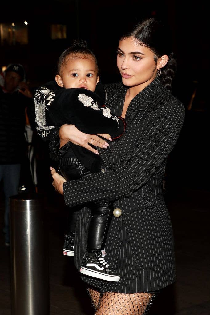 Kylie Jenner in black outfit carying daughter Stormi Webster