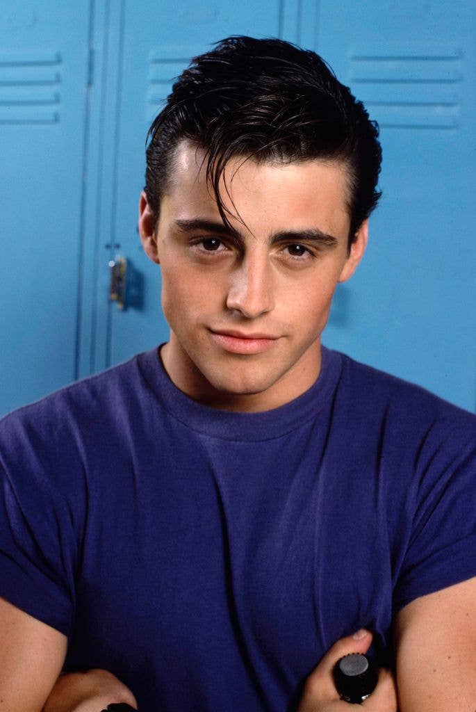 Matt LeBlanc poses in a blue tshirt against blue lockers in 1988.