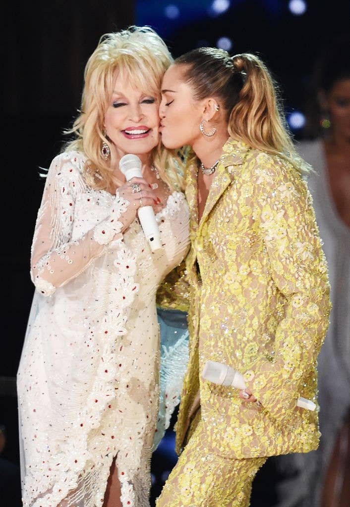 Dolly Parton and her goddaughter Miley Cyrus perform onstage in 2019