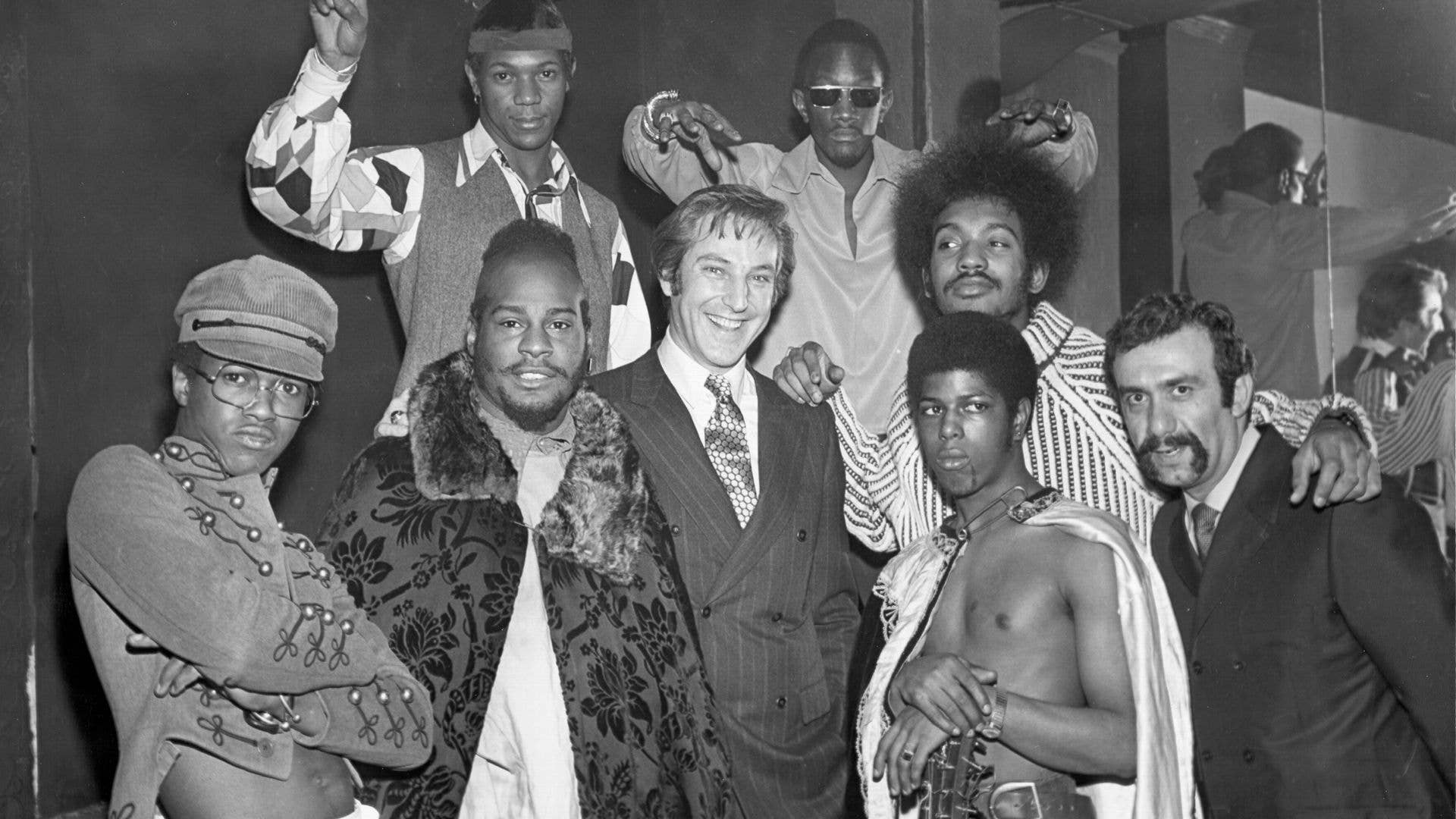Black and white photo of a group of people, including Bernie Worrell in a patterned shirt.