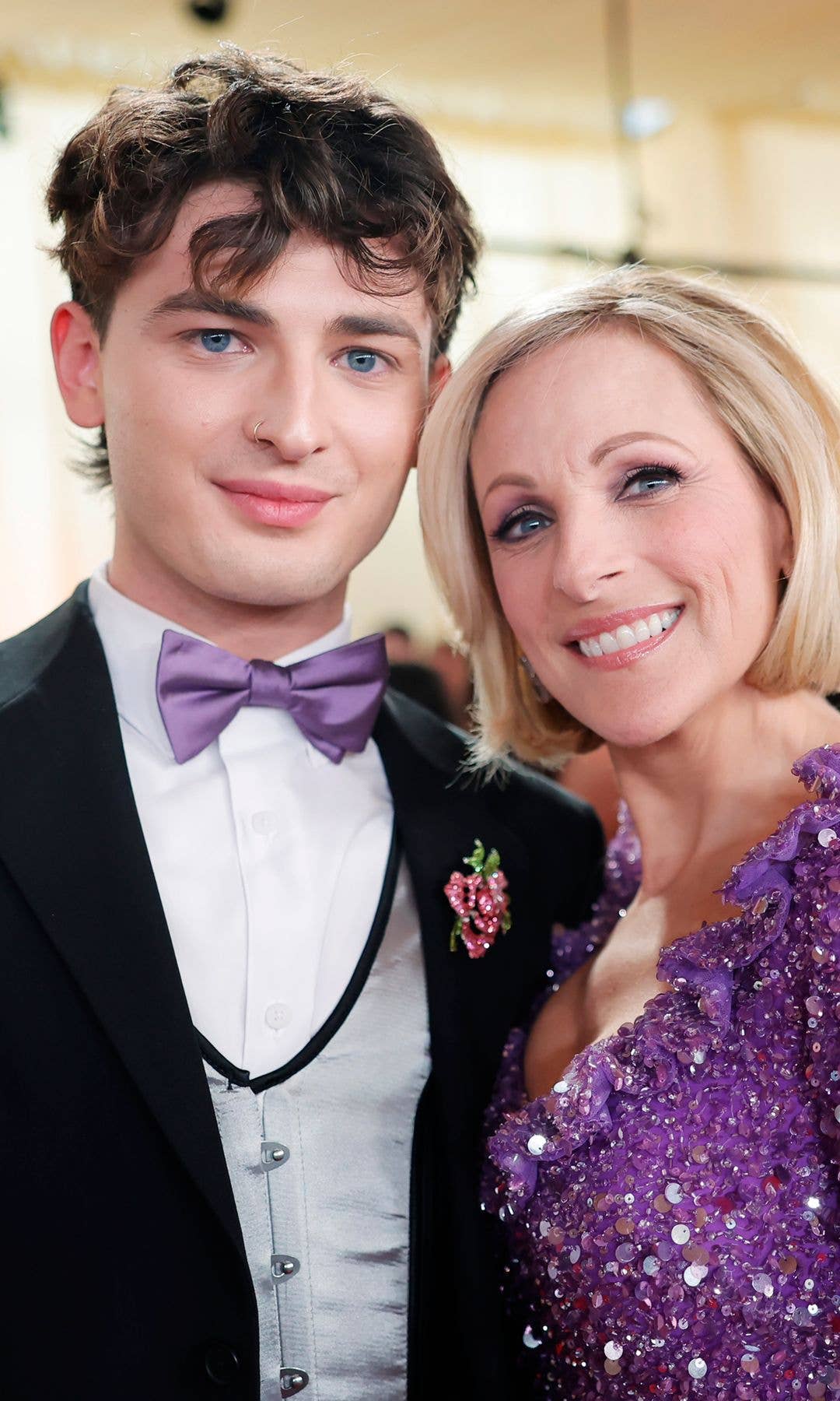 Man and woman smiling at an event, both wearing formal attire.