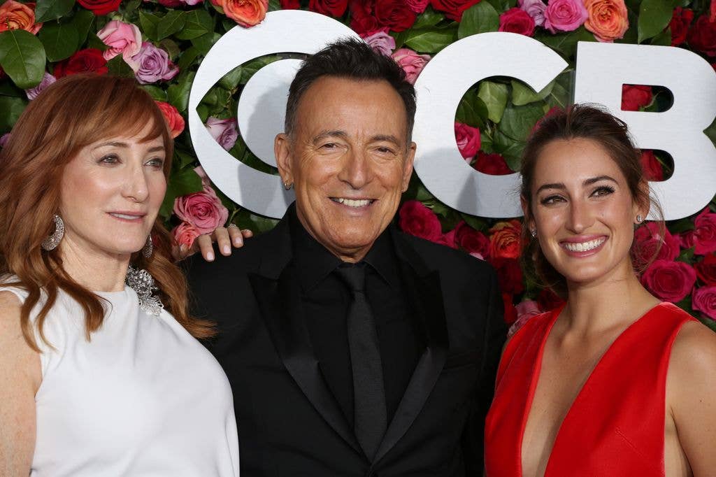 Patti Scialfa, Bruce Springsteen, Jessica Springsteen smiling with their arms around each other