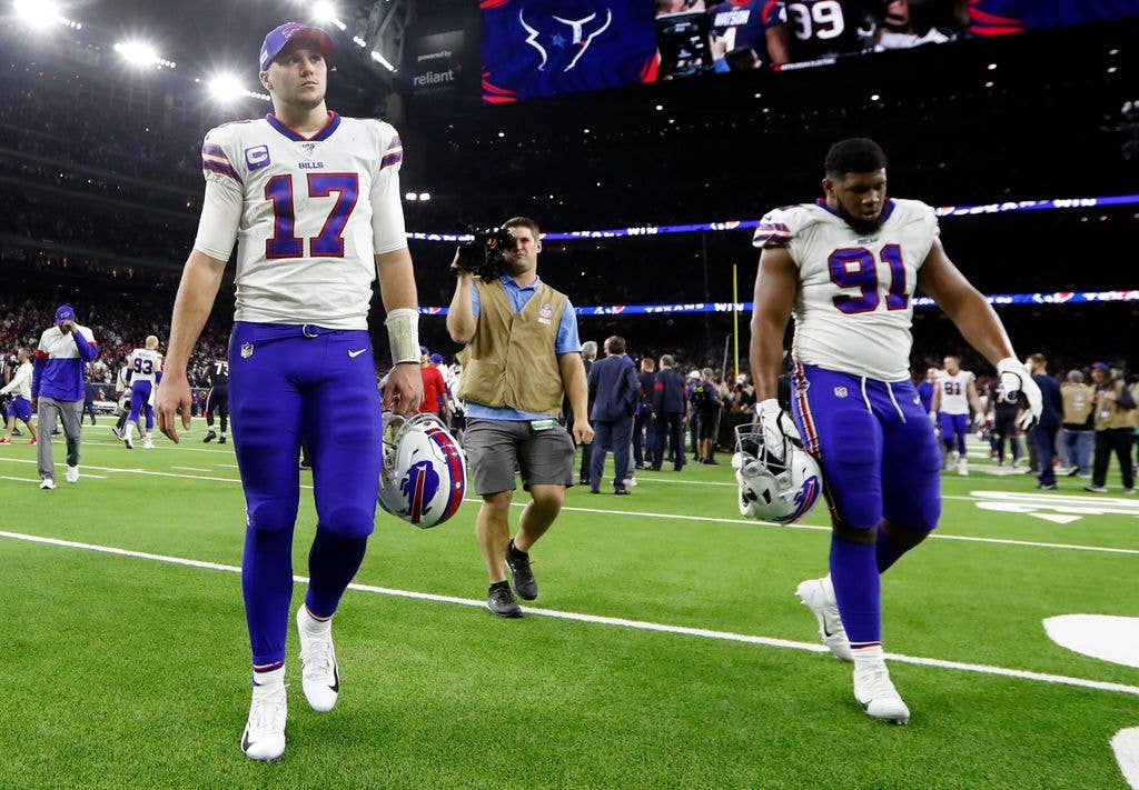 Josh Allen #17 of the Buffalo Bills and  Ed Oliver #91 walk off the field after the 22-19 overtime loss to the Houston Texans in the AFC Wild Card Playoff game at NRG Stadium on January 04, 2020 in Houston, Texas