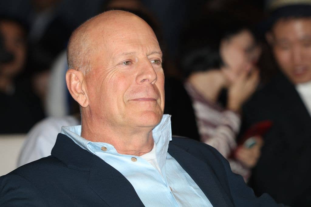 Bruce Willis in a blue shirt and dark jacket, dated 2019.