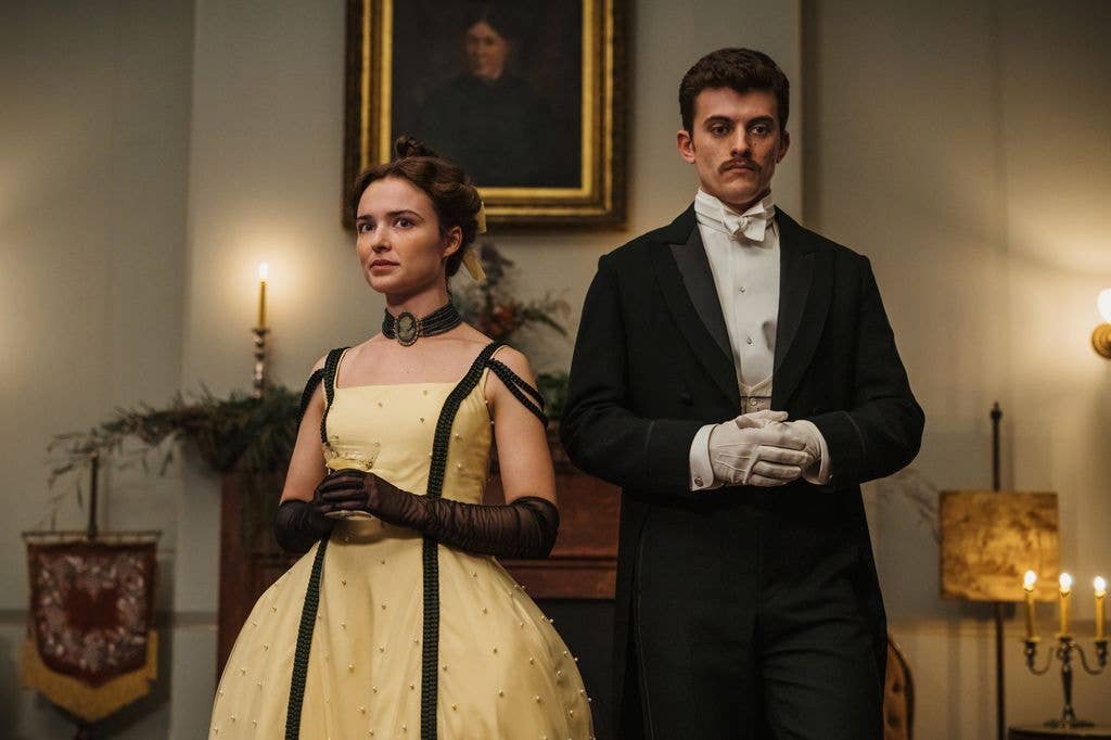 Man and woman (Phillipa Northeast and Jake Dunn) in formal attire standing together in a room with lit candles.