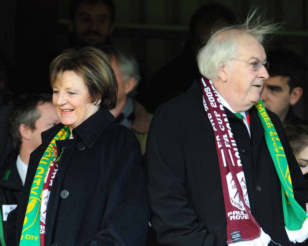 Delia Smith and an older man wearing scarves stand together at an event.