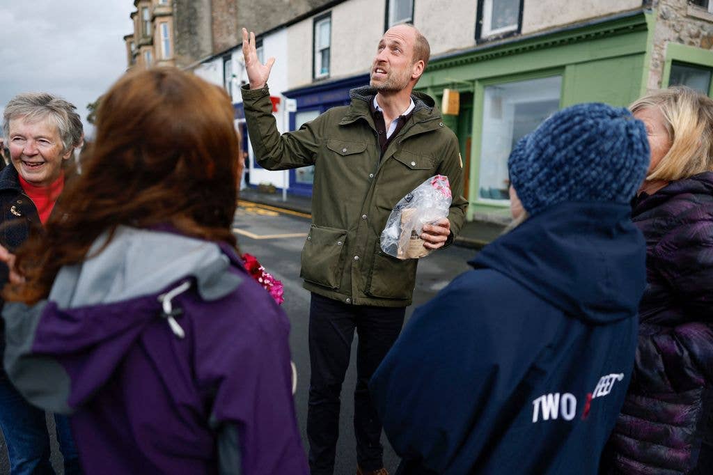 prince william in green jacket surrounded by members of the public