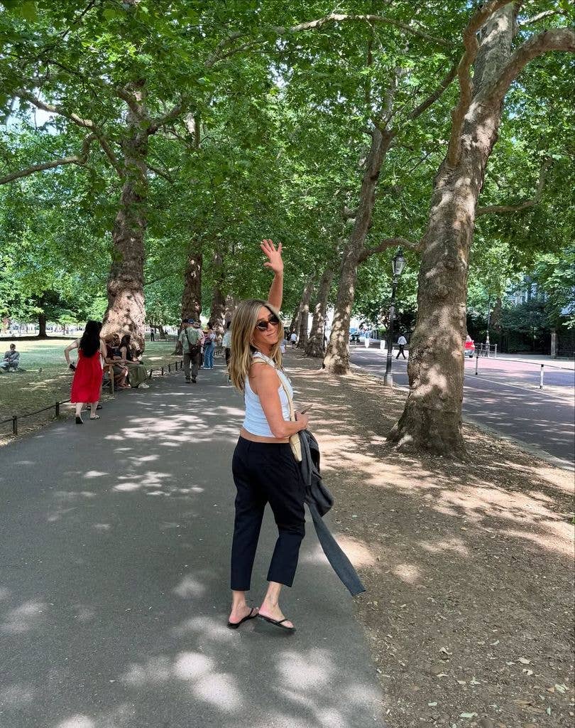 Jennifer waves in a candid shot in a tree-lined park shared on Instagram