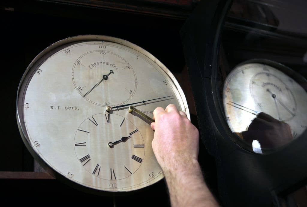 A man winding a clock face.