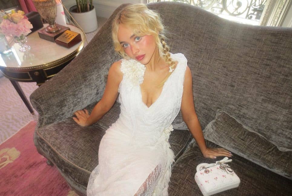 Sabrina Carpenter in a white dress on a sofa