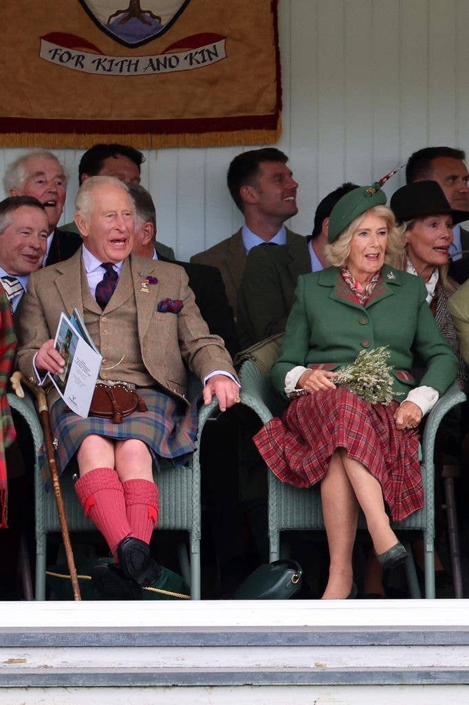 King Charles and Queen Camilla seated and smiling at an event.