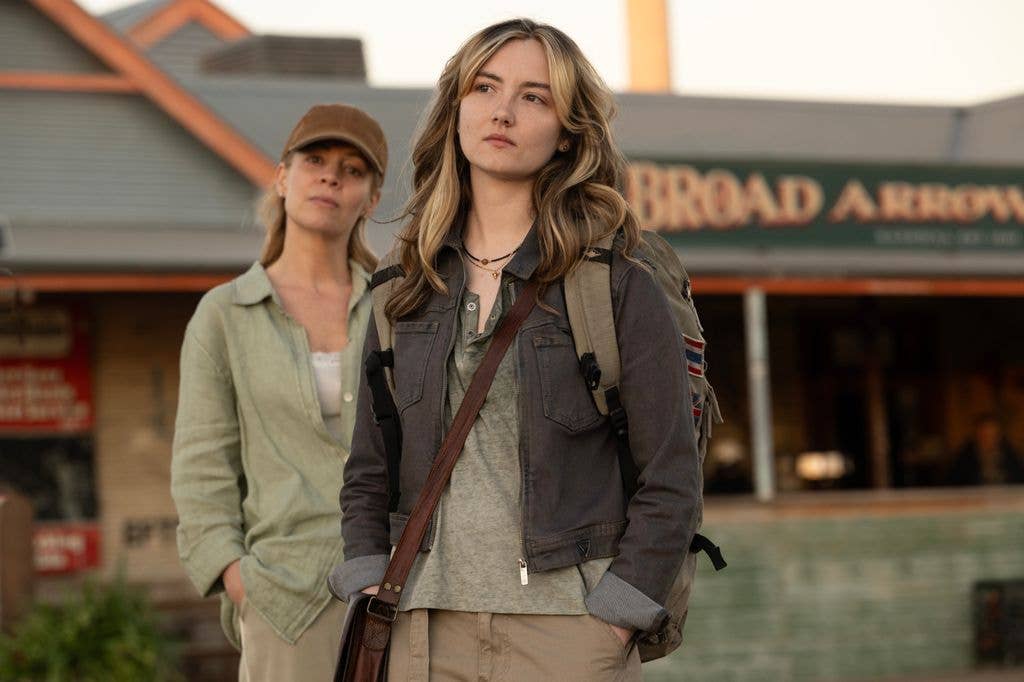 Two women stand outside a building; one is Fiona Button wearing a jacket and backpack.