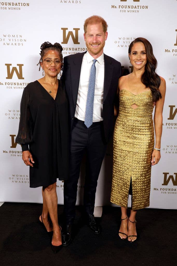 Meghan, Duchess of Sussex, stands with Prince Harry, Duke of Sussex, at an event.