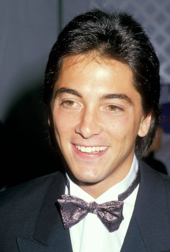 Scott Baio smiles in a tuxedo with a patterned bow tie at an event.