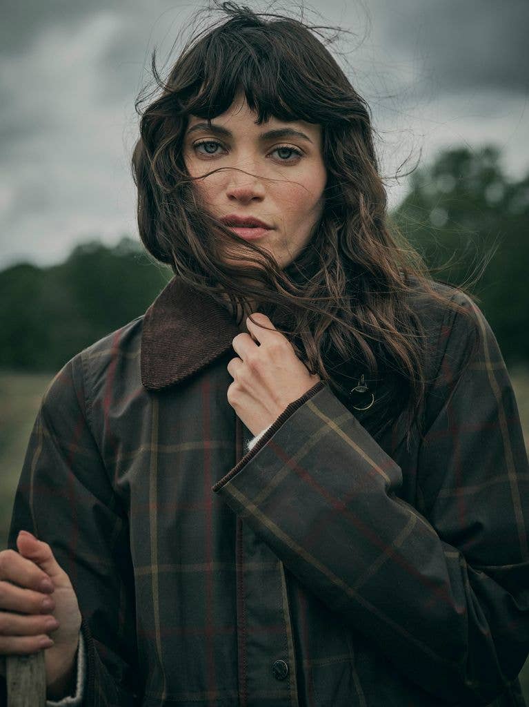 model in check coat in field