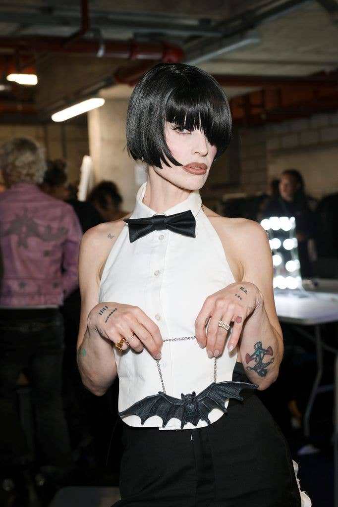 Kelly Osbourne wearing a short black wig and tuxedo shirt