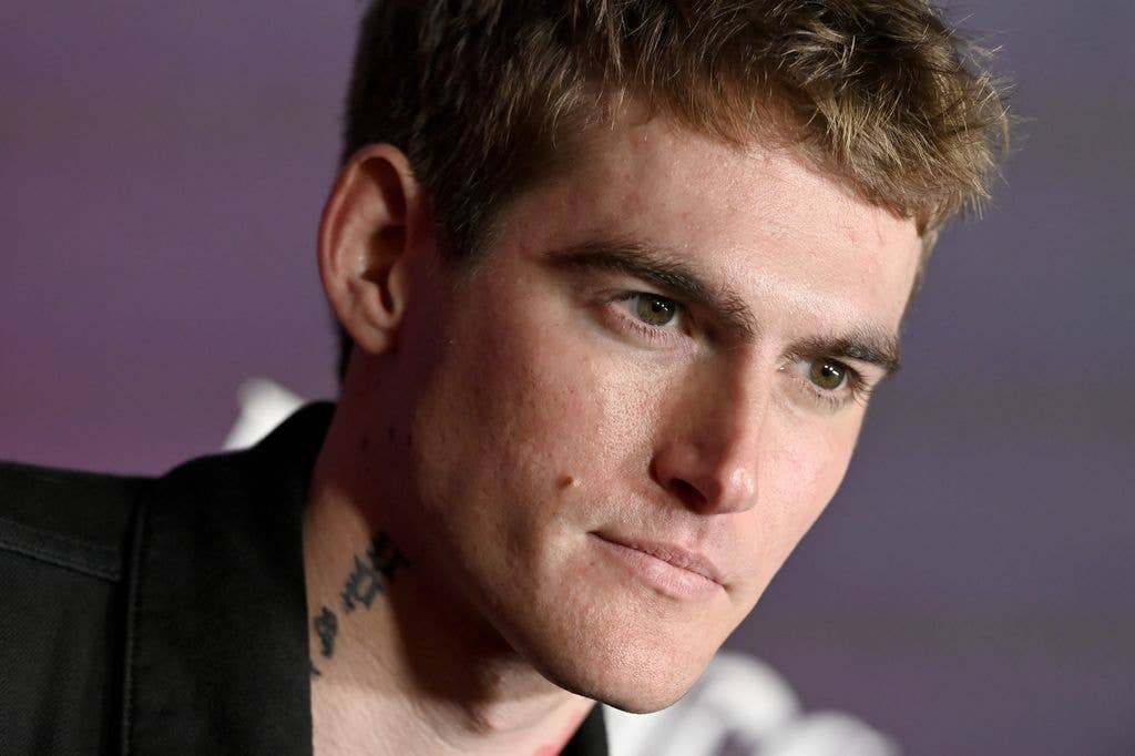 Presley Gerber close up with neck tattoos looking off to the side of the camera