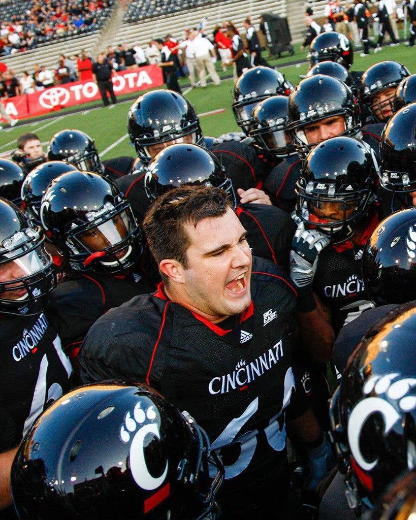 Jason Kelce in a huddle with football players at University of Cincinnati