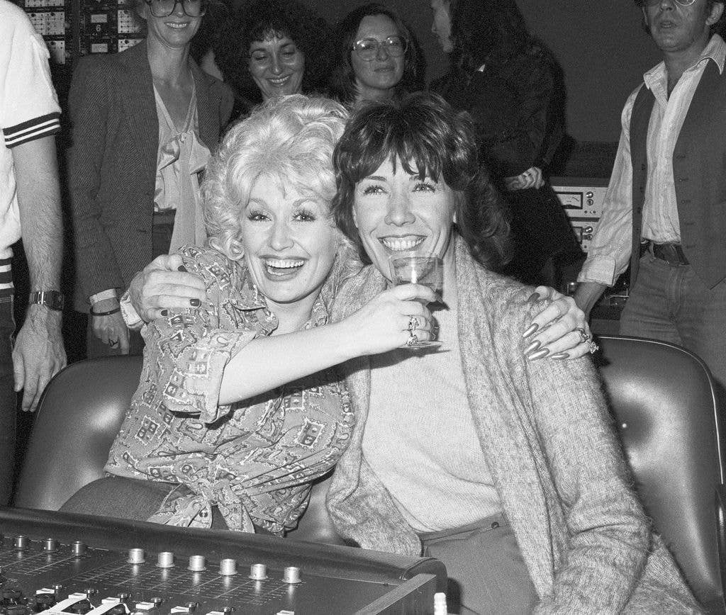 American actors Dolly Parton (left) and Lily Tomlin share a toast the last day of on-set shooting for 9 to 5 in 1979