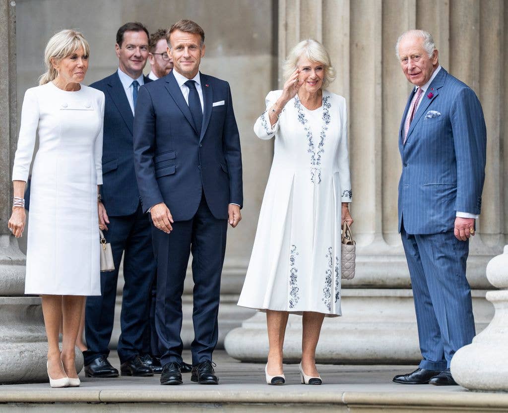 Emmanuel Macron with two women and two men, one being King Charles, on steps.