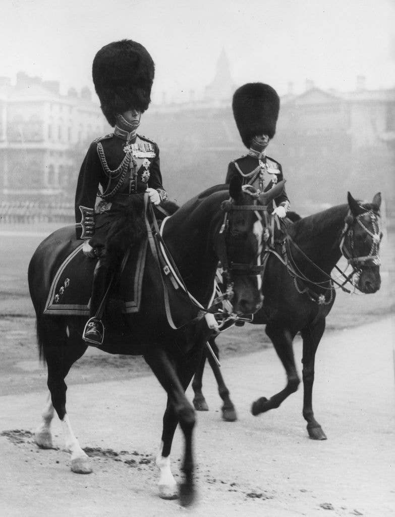 Two soldiers on horseback, one possibly George VI, in uniform and bearskin hats.