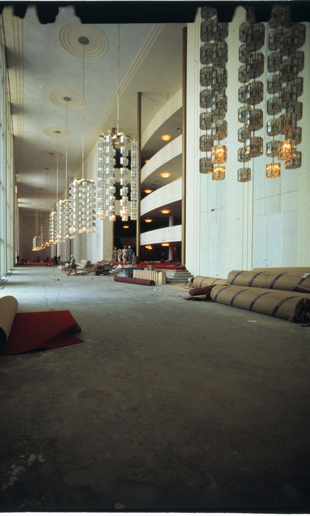 Modern crystal and metal chandeliers, a gift from Sweden, add to the glittering look of the foyer of the John F. Kennedy Center for the Performing Arts, which opens formally September 9th. The center, whose total cost is estimated at $68,000,000, houses a theater, an opera house, a concert hall, and a film theater.