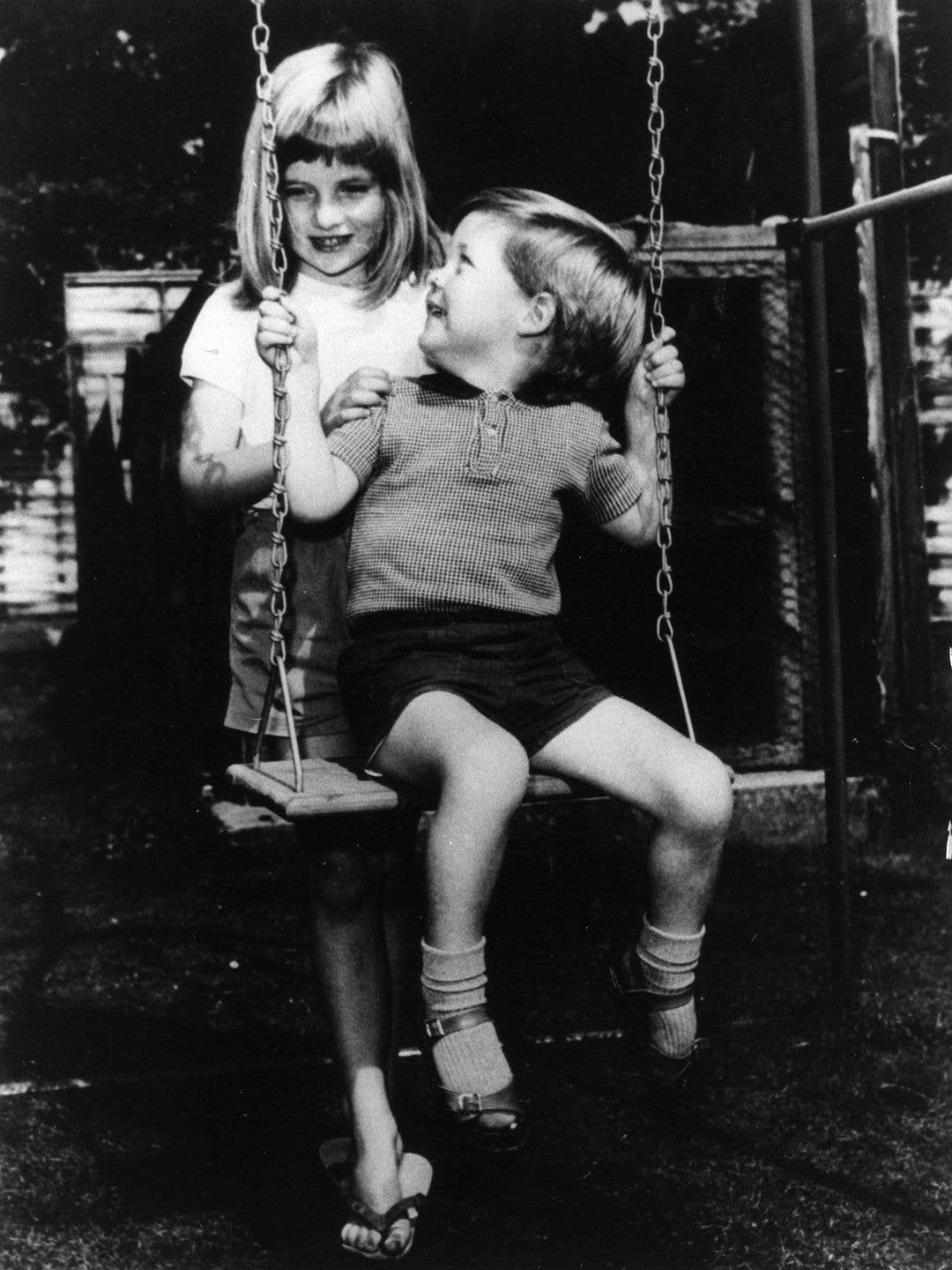 A young Princess Diana pushing her young brother Charles Spencer on a swing