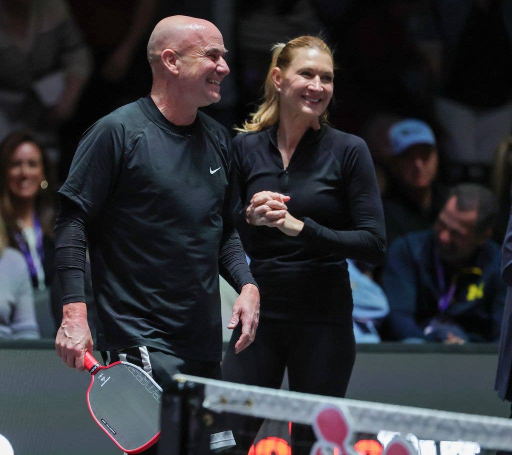 Andre Agassi and Steffi Graf smiling and standing together at a sports event.