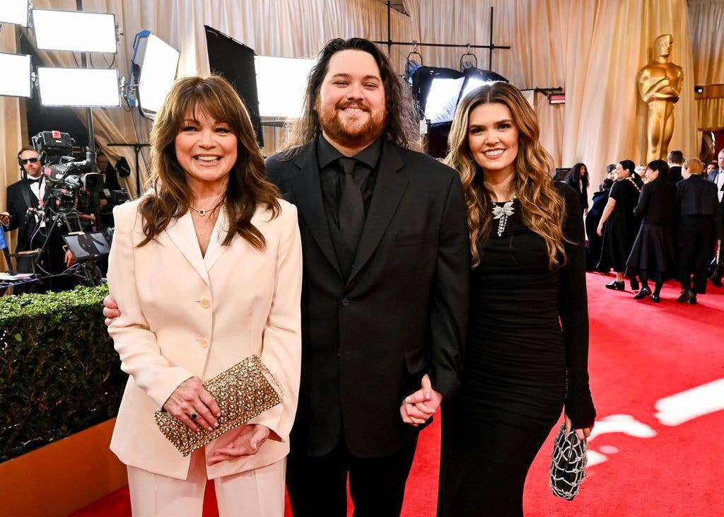 Valerie Bertinelli, Wolfgang Van Halen and Andraia Allsop smile together on the red carpet at the Oscars, with an Oscar statue visible in the background.