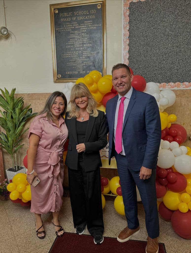Goldie posing with teachers at the school 