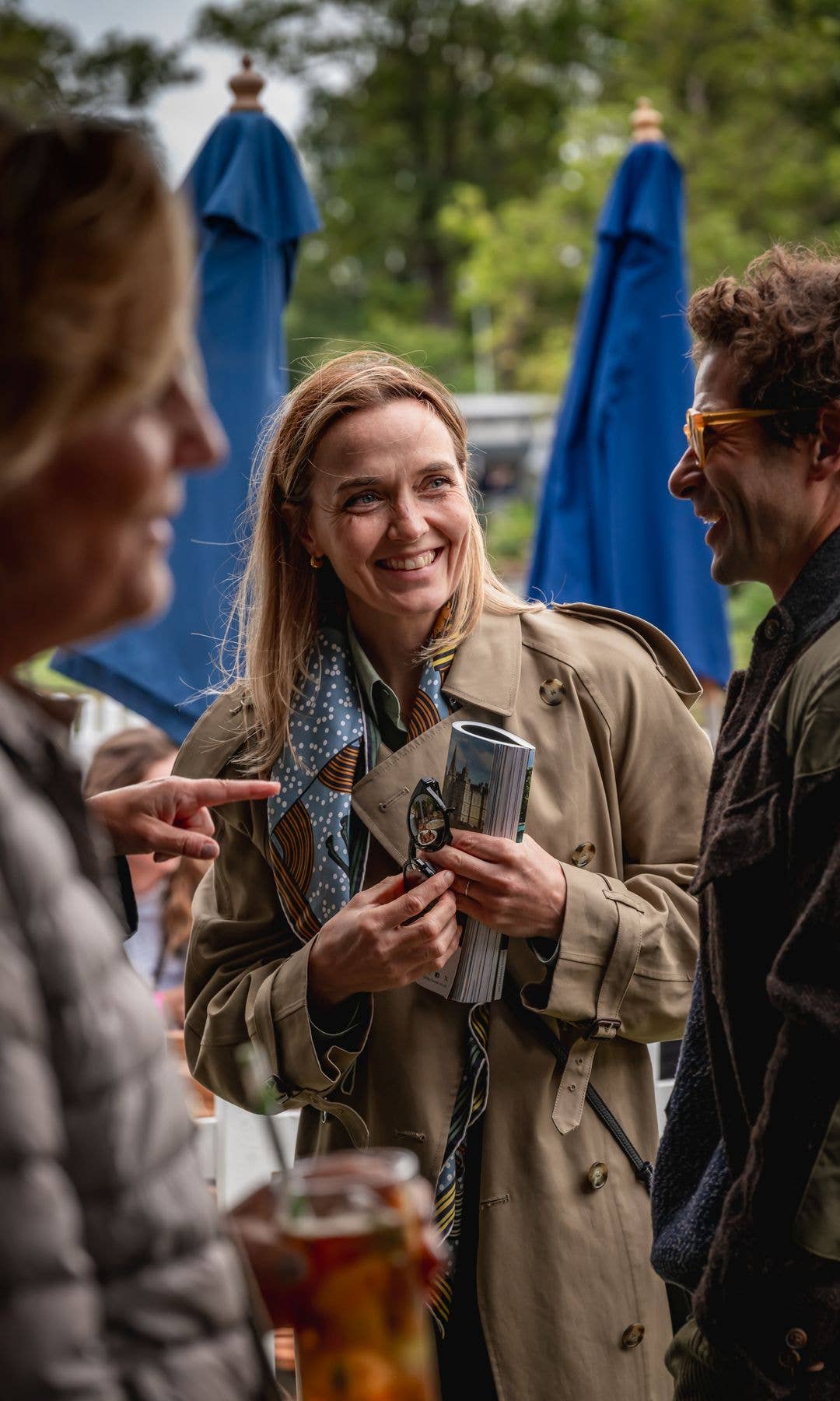Victoria Pendleton in trench coat holds magazine as she chats to Sam Waley-Cohen
