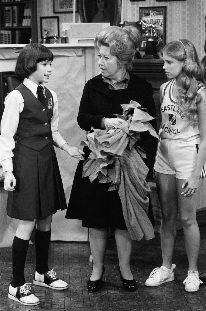 Molly Ringwald stood in a school uniform with shirt, tie, waistcoat and skirt with Charlotte Rae and Julie Piekarski.