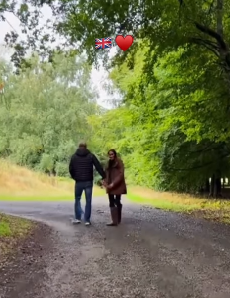 Prince Harry and Meghan Markle holding hands on a woodland walk