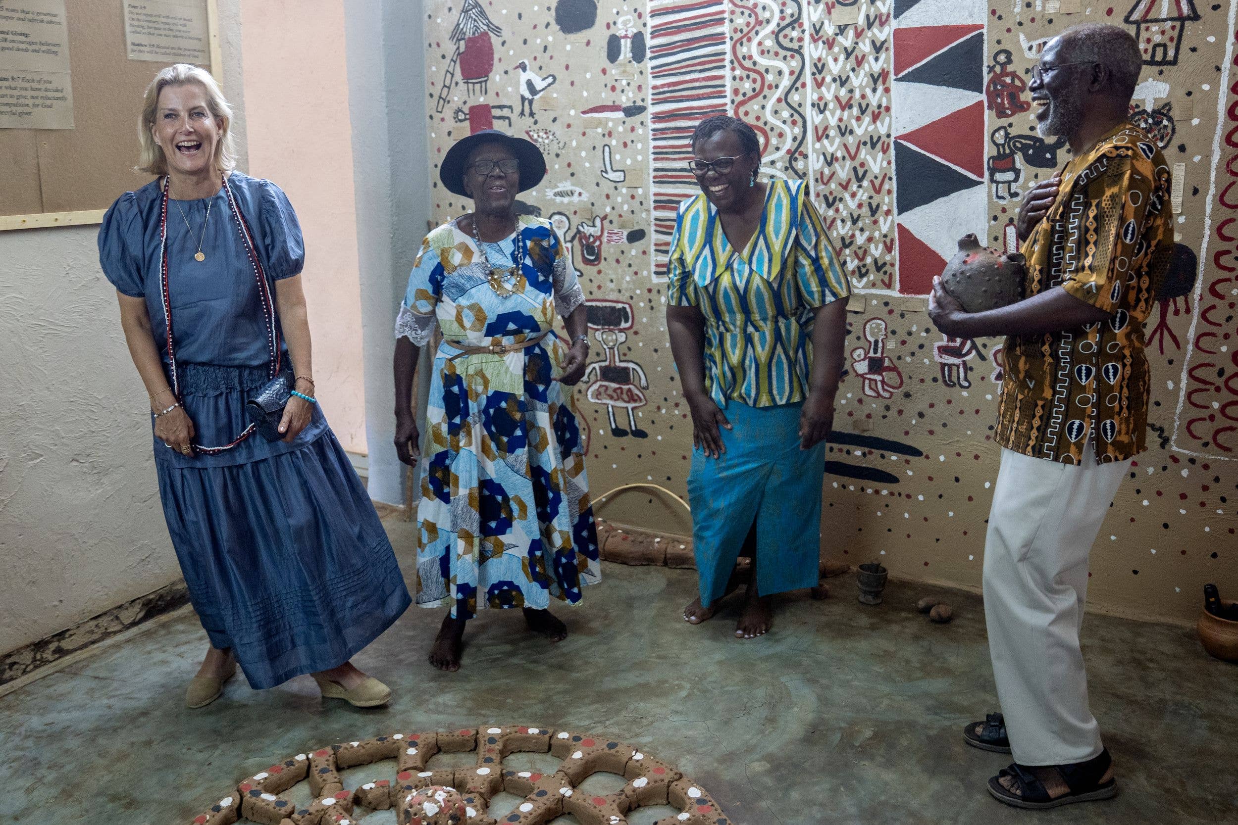 Sophie laughs as the artists Lawrence Yombwe (right) and his wife Agness Buya Yombwe (second right) describe the "dialogue dynamic" pot, which is designed to show the futility to two people talking at the same time